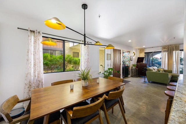 dining space with a wealth of natural light and concrete floors