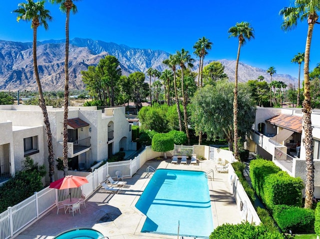 view of swimming pool with a mountain view and a patio