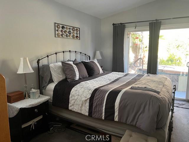 bedroom featuring carpet flooring, access to outside, and lofted ceiling