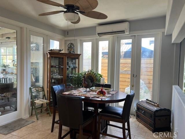 tiled dining space with french doors, a wall mounted AC, and ceiling fan