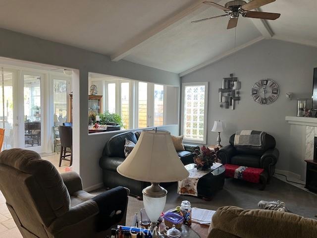 living room with a fireplace, lofted ceiling with beams, and ceiling fan