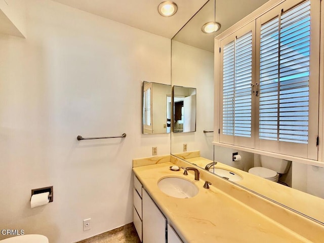 bathroom featuring tile patterned floors, vanity, and toilet