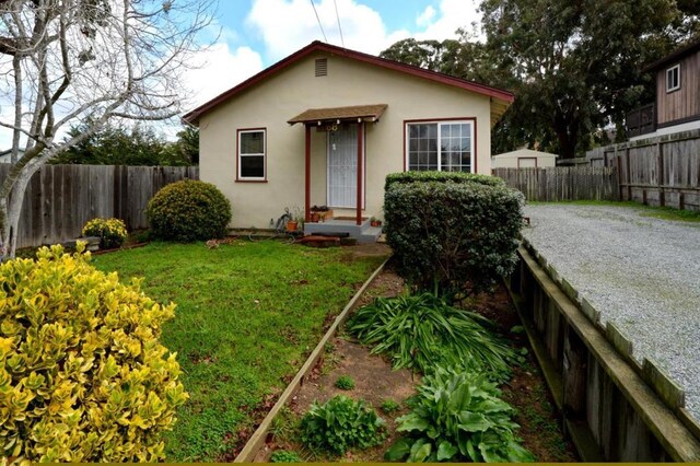 bungalow featuring a front lawn