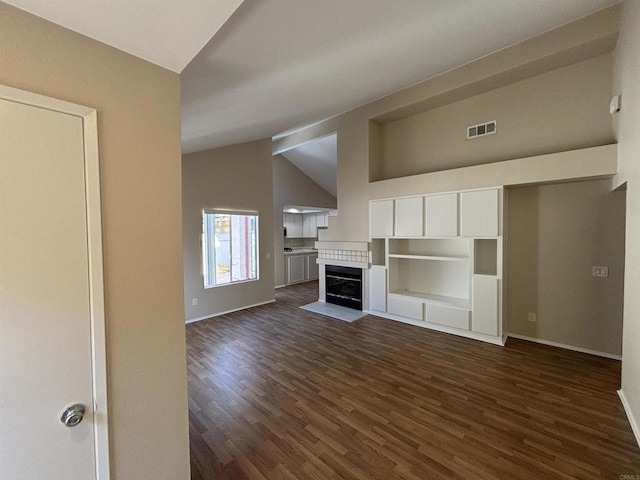 unfurnished living room featuring dark hardwood / wood-style flooring and lofted ceiling