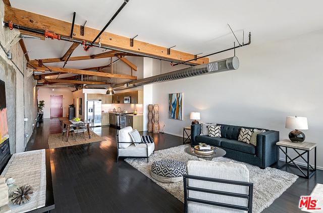 living room with a fireplace, dark hardwood / wood-style flooring, beamed ceiling, and high vaulted ceiling