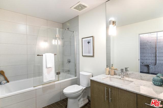 full bathroom featuring toilet, tile patterned flooring, vanity, and combined bath / shower with glass door