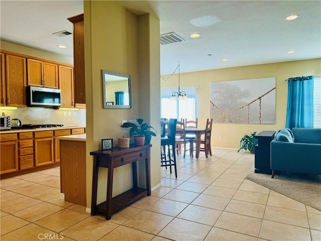 kitchen featuring a chandelier, gas stovetop, and light tile patterned flooring