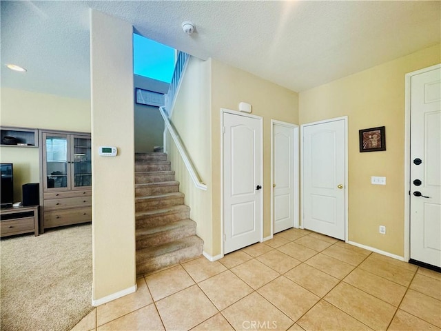 tiled foyer entrance with a textured ceiling