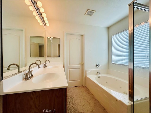 bathroom featuring tiled tub and vanity