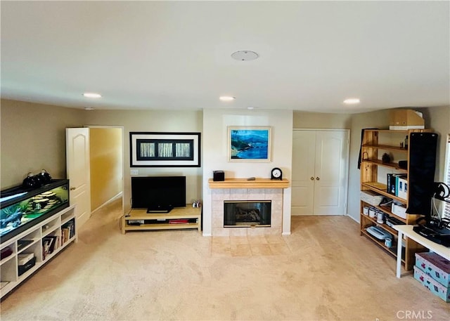 carpeted living room featuring a tiled fireplace