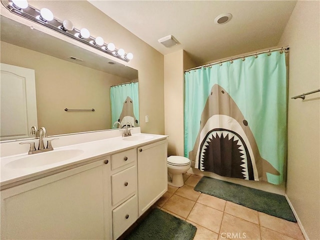 bathroom with tile patterned flooring, vanity, and toilet