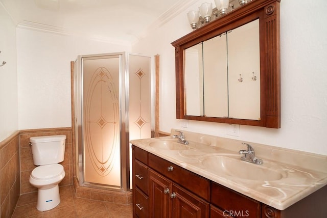 bathroom with vanity, tile patterned floors, crown molding, toilet, and tile walls