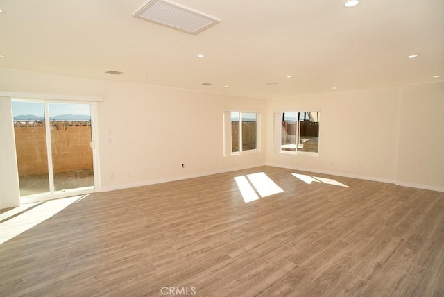 spare room featuring wood-type flooring, basketball court, and a wealth of natural light