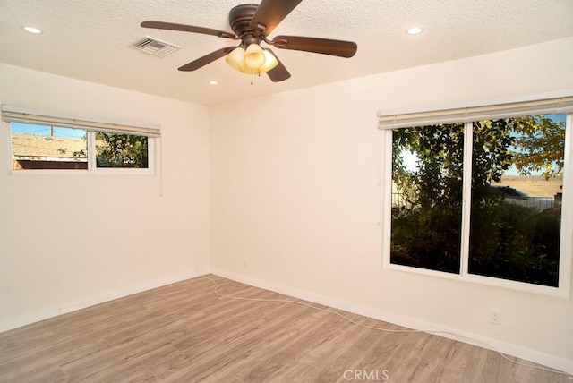 unfurnished room with ceiling fan, light hardwood / wood-style floors, and a textured ceiling