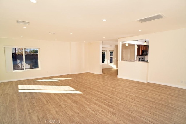 unfurnished living room with basketball court and light hardwood / wood-style flooring