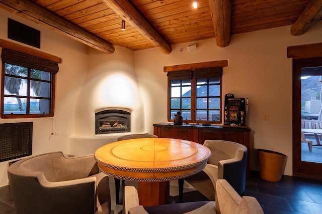 tiled dining space featuring wooden ceiling and beam ceiling