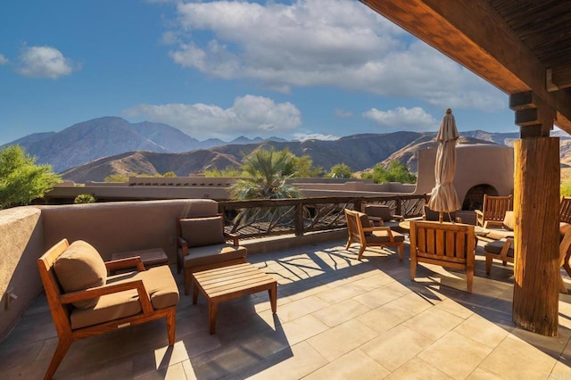 view of patio with a mountain view and an outdoor living space with a fireplace