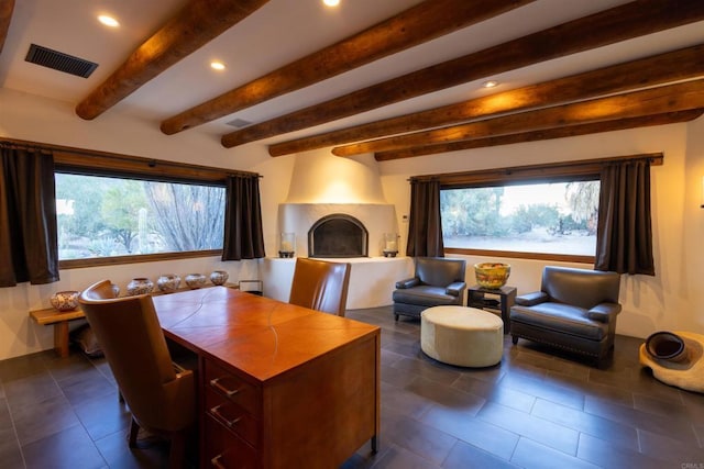 interior space featuring beamed ceiling and a large fireplace