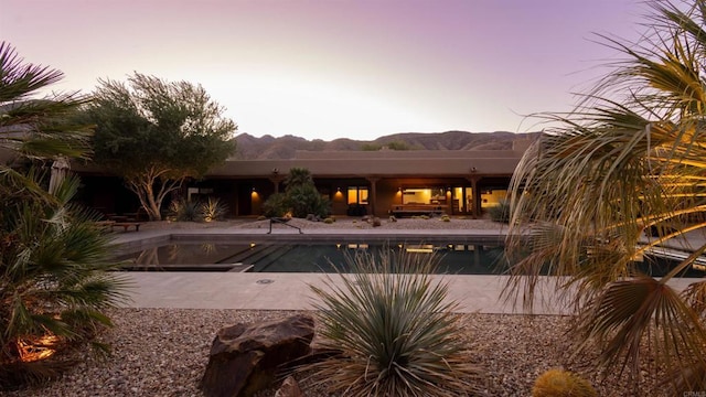 pool at dusk featuring a patio