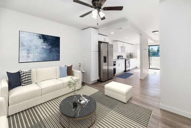 living room with hardwood / wood-style flooring and ceiling fan