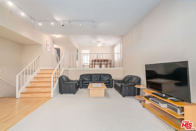 living room with ceiling fan, track lighting, and hardwood / wood-style flooring