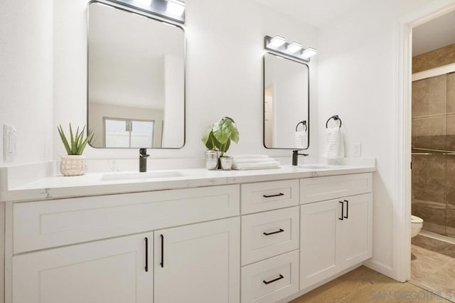 bathroom featuring tile patterned floors, vanity, toilet, and walk in shower