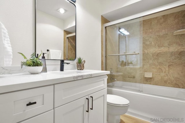 full bathroom featuring vanity, toilet, combined bath / shower with glass door, and wood-type flooring