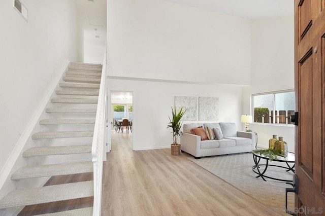 stairs with a high ceiling, hardwood / wood-style flooring, and plenty of natural light