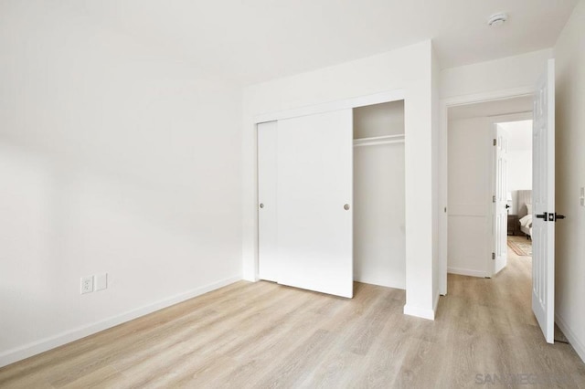 unfurnished bedroom with a closet and light hardwood / wood-style flooring