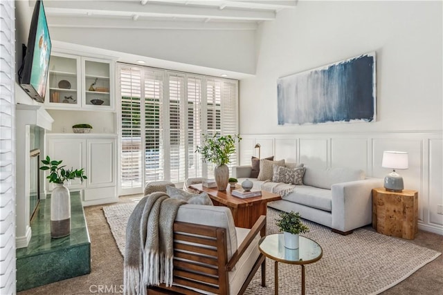 carpeted living room with vaulted ceiling with beams