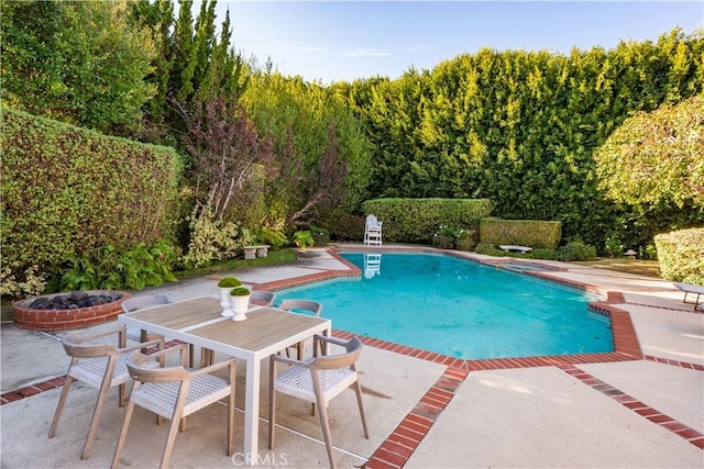 view of pool with a diving board and a patio area