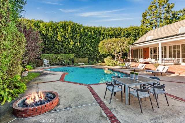 view of pool featuring a patio and a fire pit