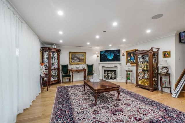 living room with crown molding and light hardwood / wood-style flooring