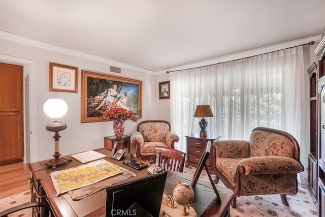 living area featuring light wood-type flooring and crown molding