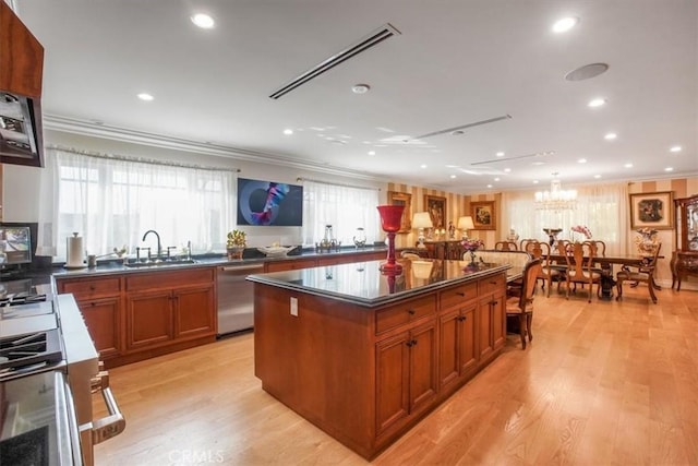 kitchen featuring crown molding, sink, light hardwood / wood-style flooring, dishwasher, and a center island