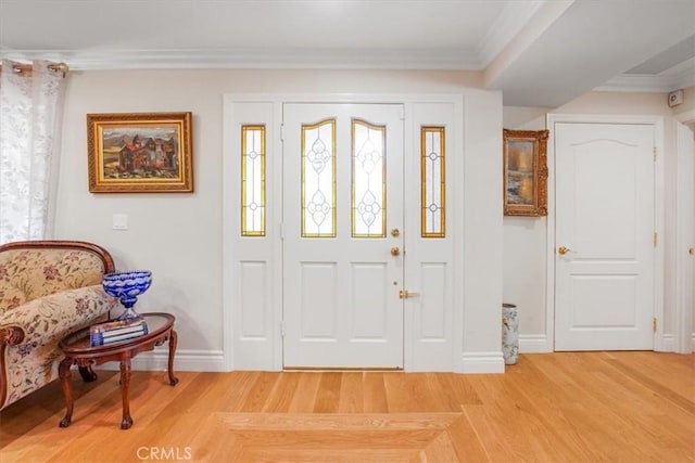 foyer with hardwood / wood-style flooring and crown molding