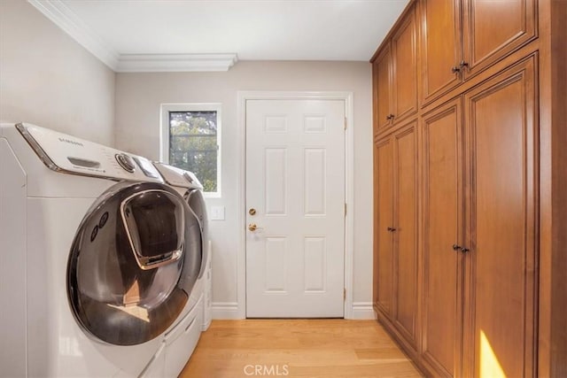 laundry area with washer and dryer, cabinets, light hardwood / wood-style flooring, and ornamental molding