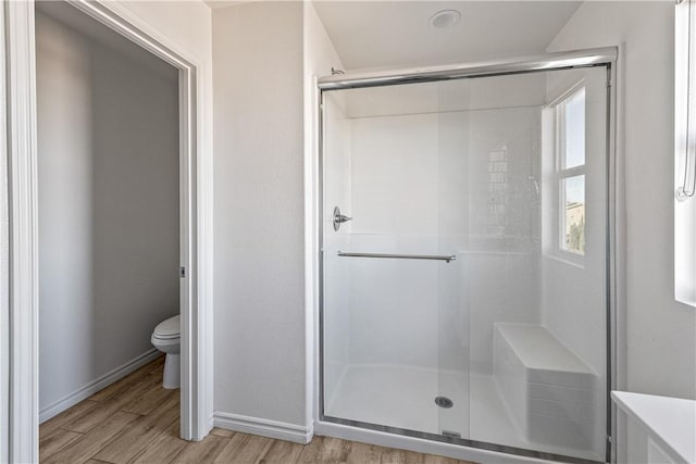 bathroom featuring wood-type flooring, toilet, and walk in shower