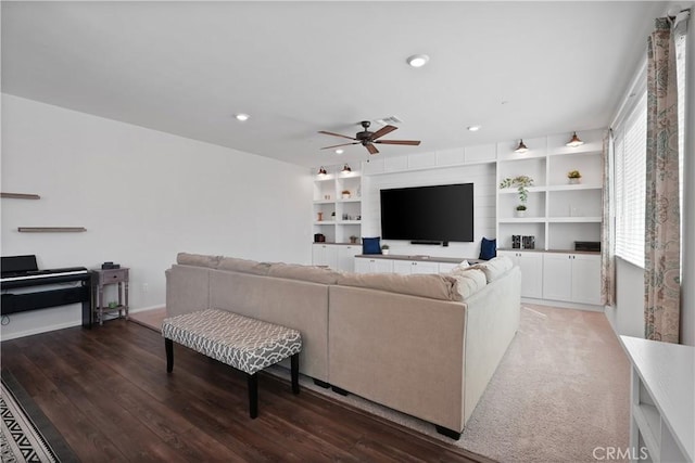 living room with ceiling fan and dark wood-type flooring