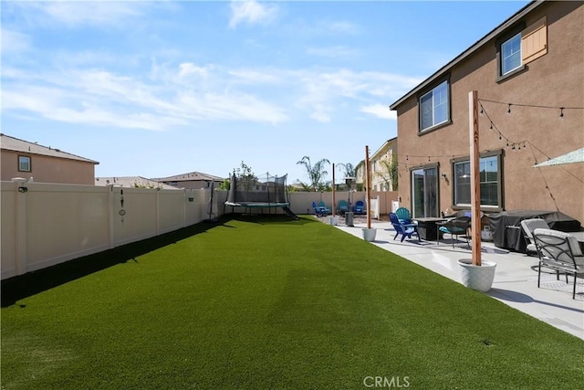 view of yard featuring a patio and a trampoline