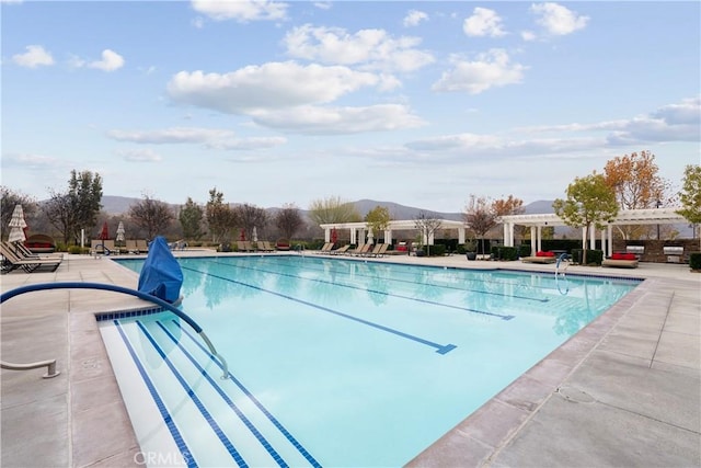 view of swimming pool featuring a mountain view and a patio