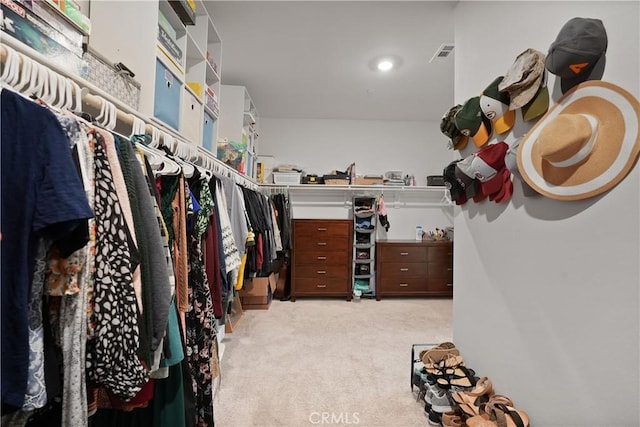 walk in closet featuring light carpet