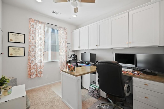 carpeted office with ceiling fan and built in desk