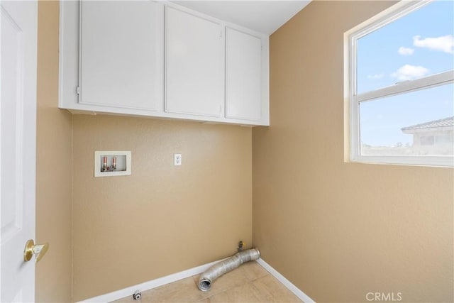 laundry area with washer hookup, tile patterned floors, and cabinets