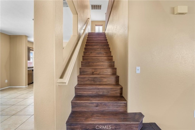 stairway with tile patterned floors