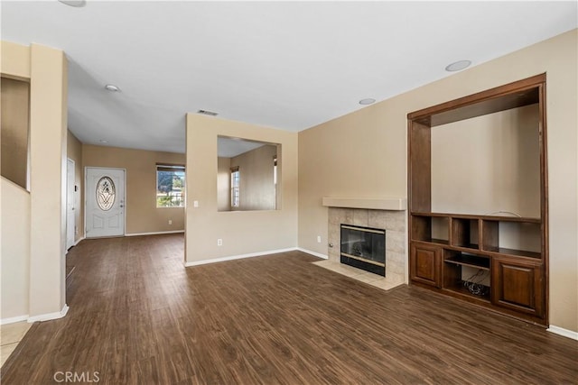 unfurnished living room with dark wood-type flooring and a fireplace