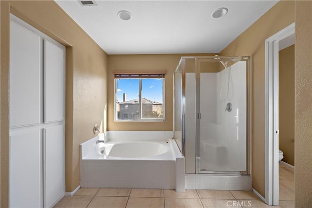 bathroom with plus walk in shower, tile patterned floors, and toilet