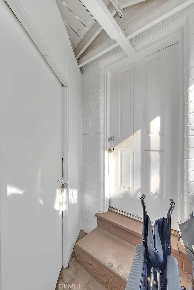 stairs with vaulted ceiling with beams