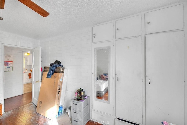 bedroom with ceiling fan and a textured ceiling