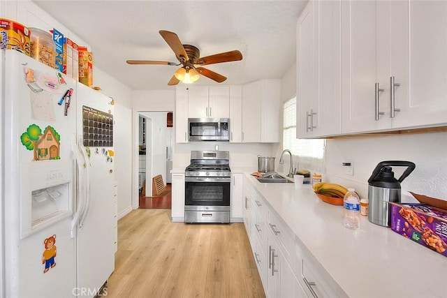 kitchen featuring white cabinetry, sink, stainless steel appliances, and light hardwood / wood-style flooring